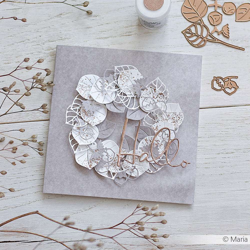 Eine handgefertigte Karte von Alexandra Renke zeigt einen dekorativen Papierkranz aus Designpapieren und das Wort "Hallo" auf einer hellen Holzoberfläche.