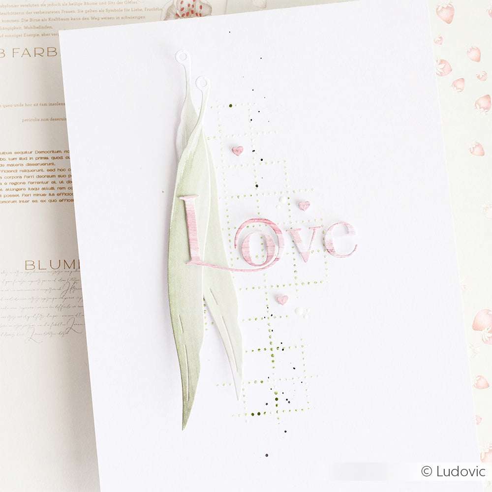 Eine handgefertigte Karte von Alexandra Renke mit "Love" in Rosa, Designpapiere-Hintergrund, mit der Motivstanze Weidenblätter geschnittene Blätter, Herzverzierungen und ein dezentes Gittermuster.