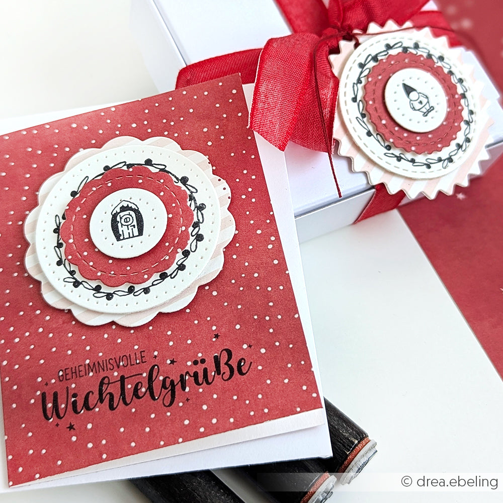 Alexandra Renke Weihnachtskarte mit Wellenschliff, deutschem Text und festlichem Akzent-Stempel, gepaart mit einer passenden Geschenkbox mit roter Schleife.