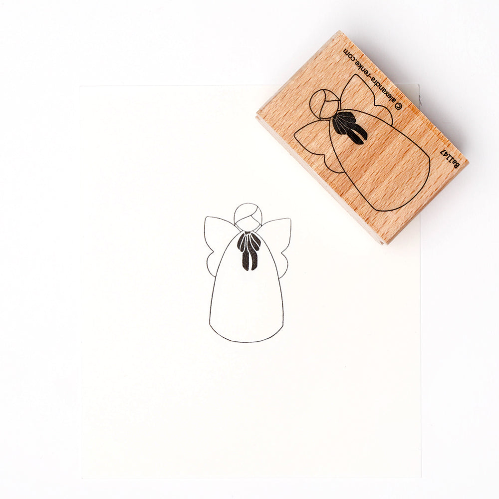 Ein Alexandra Renke Holzstempel erzeugt einen schwarzen Tintendruck eines einfachen, stilleren Engels auf weißem Papier.