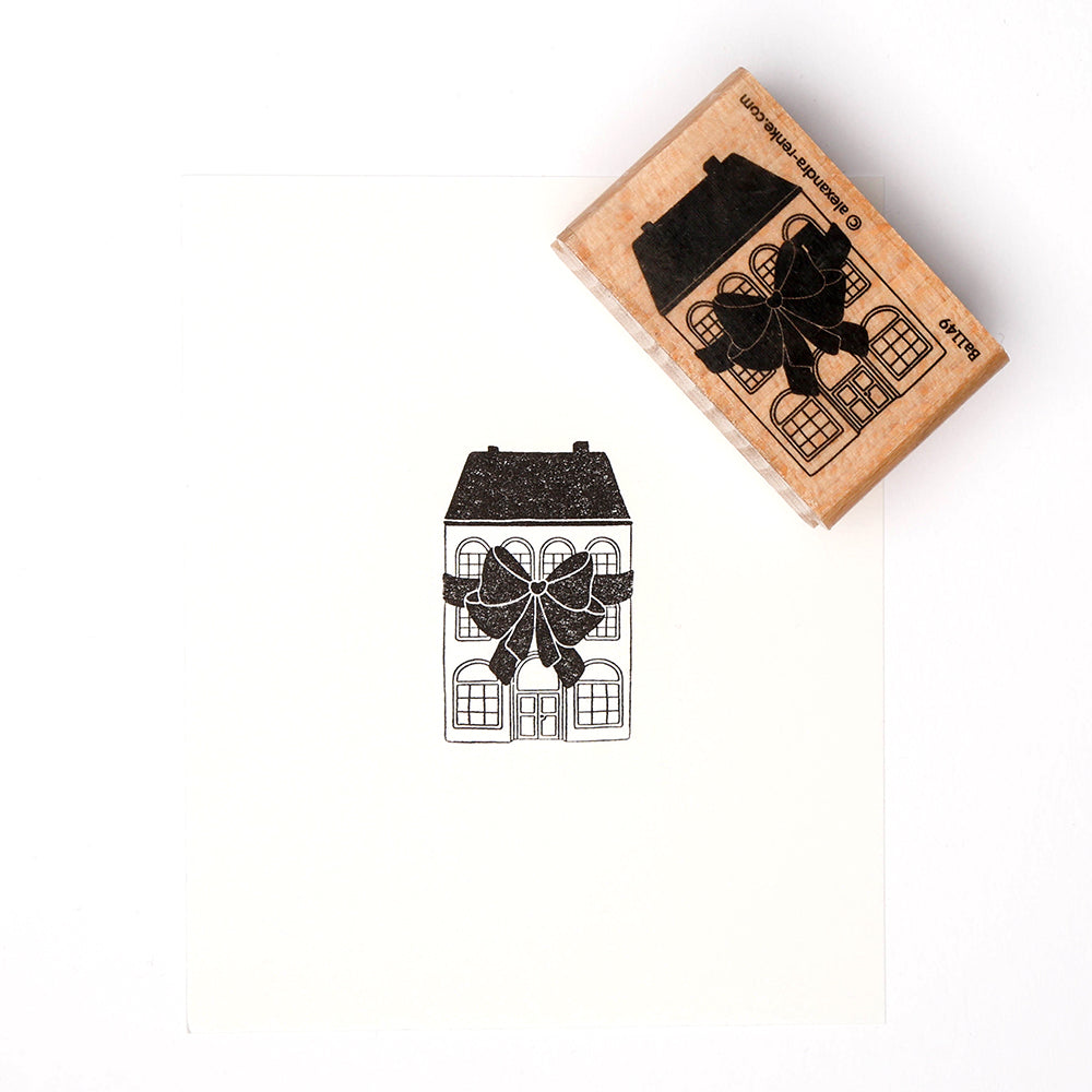 Ein Alexandra Renke Holzstempel mit Stempelgummi stempelt ein bezauberndes Festliches Schleifenhaus - ein Haus mit einer großen Schleife - auf knackig weißes Papier.