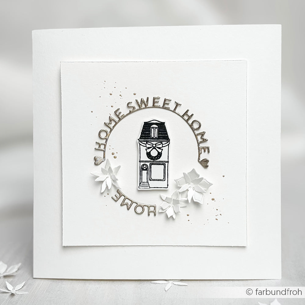 Die quadratische weiße Karte von Alexandra Renke zeigt eine Hausillustration und "HOME SWEET HOME" in einem Kreis, verziert mit Papierblumen - ideal für Papierprojekte mit Ihrem Lieblingsholzstempel.