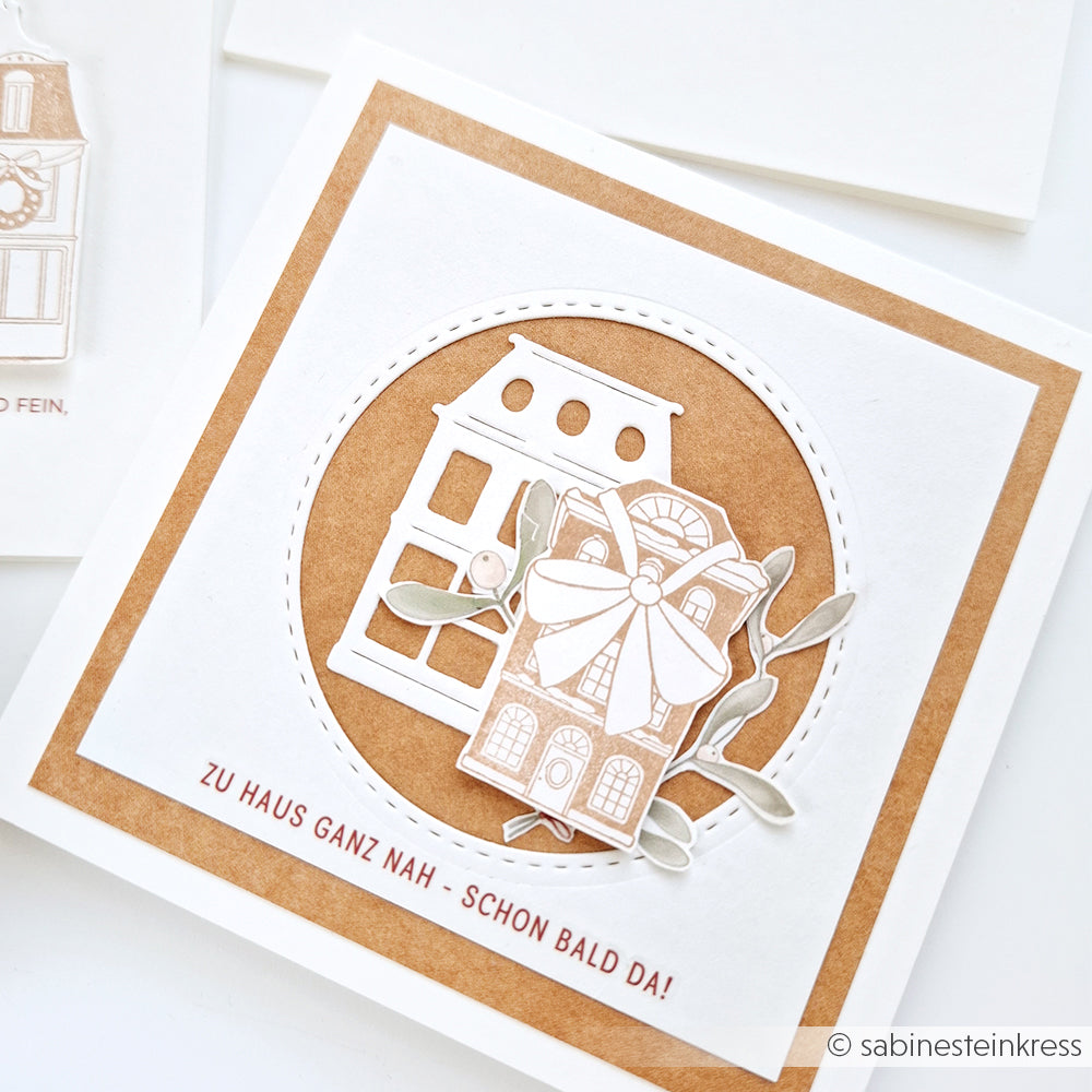 Quadratische Karte von Alexandra Renke mit einer Hausillustration, Schleife und Blättern auf braunem Hintergrund mit deutschem Text - ideal für Papierprojekte mit Ihrem Lieblingsstempelkissen.