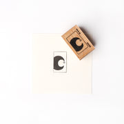 Ein Alexandra Renke Holzstempel schafft einen schwarzen Halbmond Leuchtender Mond mit Sternabdruck auf knackig weißem Papier.