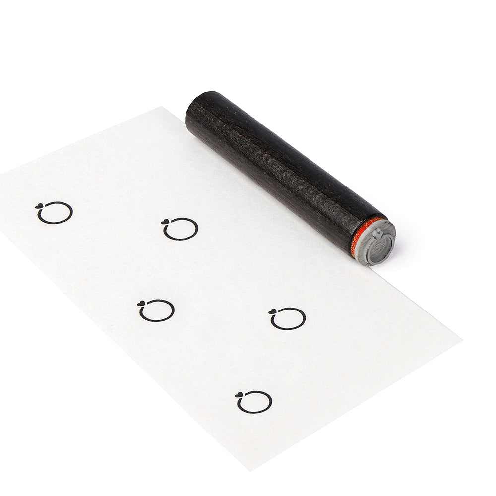 Ein runder Stempel von Alexandra Renke hinterlässt wiederholte kreisförmige Tintenabdrücke in einem Gittermuster auf Papier.