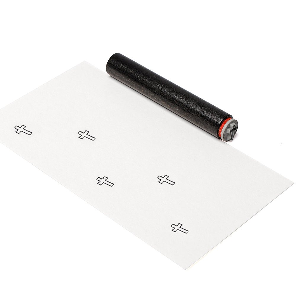 Der schwarze Mini Kreuz Stempelroller von Alexandra Renke druckt saubere Reihen von kleinen Kreuzen auf ein weißes Blatt Papier und erzeugt bei jedem Gebrauch gestochen scharfe Muster.