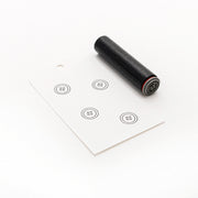Ein schwarzer Alexandra Renke Holzstempel und eine weiße Karte mit fünf gestempelten Knopfmotiven, jeweils mit vier Löchern. Ideal als Mini Knopf Stempel oder für Anfänger.