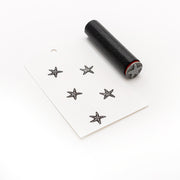 Der Alexandra Renke Akzent-Stempel Mini Seestern zaubert fünf Seesterne auf ein knackig weißes Papierschild, die alle mit einem handgeschnitzten Stempel auf einem sauberen weißen Hintergrund hergestellt wurden.