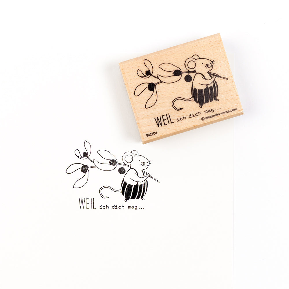 Ein Holzstempel und sein Abdruck einer Maus, die Mistelzweige hält, mit dem deutschen Text „WEIL ich dich mag“ – ideal für Papierprojekte.