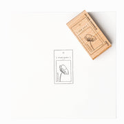 Ein Holzstempel von Alexandra Renke aus hochwertigem Holz mit einfachem Blumenmotiv und "FÜR DICH" Text auf weißem Papier.