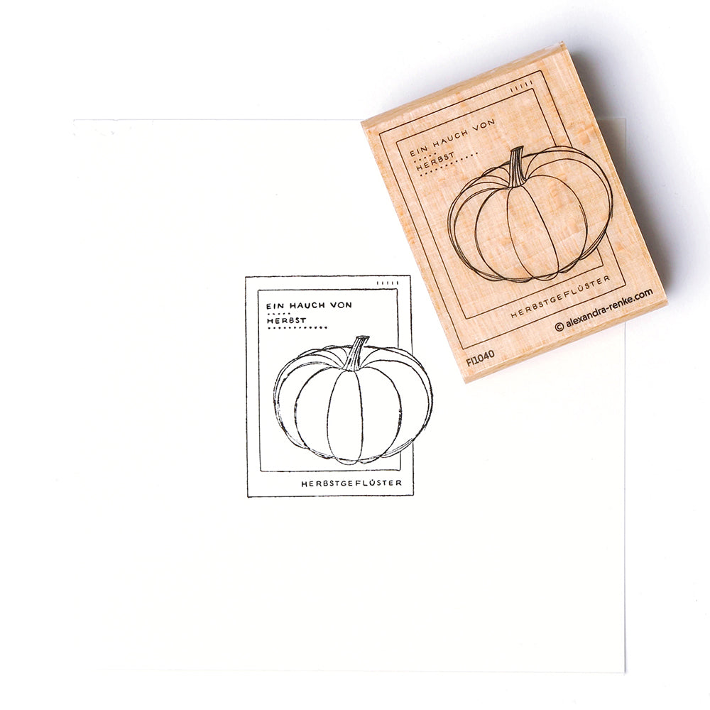 Ein Kürbis-Holzstempel von Alexandra Renke zeigt sein auf weißes Papier gestempeltes "Herbstgeflüster"-Design.