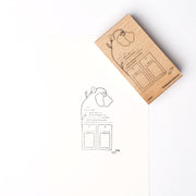 Ein Alexandra Renke Holzstempel mit einer Blume und zwei beschrifteten Schachteln, die neben dem gestempelten Aufdruck auf weißem Papier zu sehen sind - ideal, um Ihren Papierprojekten eine charmante Note zu verleihen.