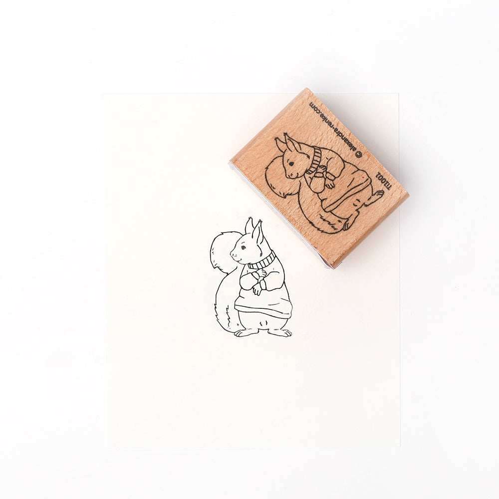 Der Holzstempel von Alexandra Renke und sein Abdruck zeigen einen aufrecht stehenden Hasen in einem kuscheligen Pullover - ein entzückendes Motiv, das sich perfekt zum Basteln und Gestalten von Karten eignet.