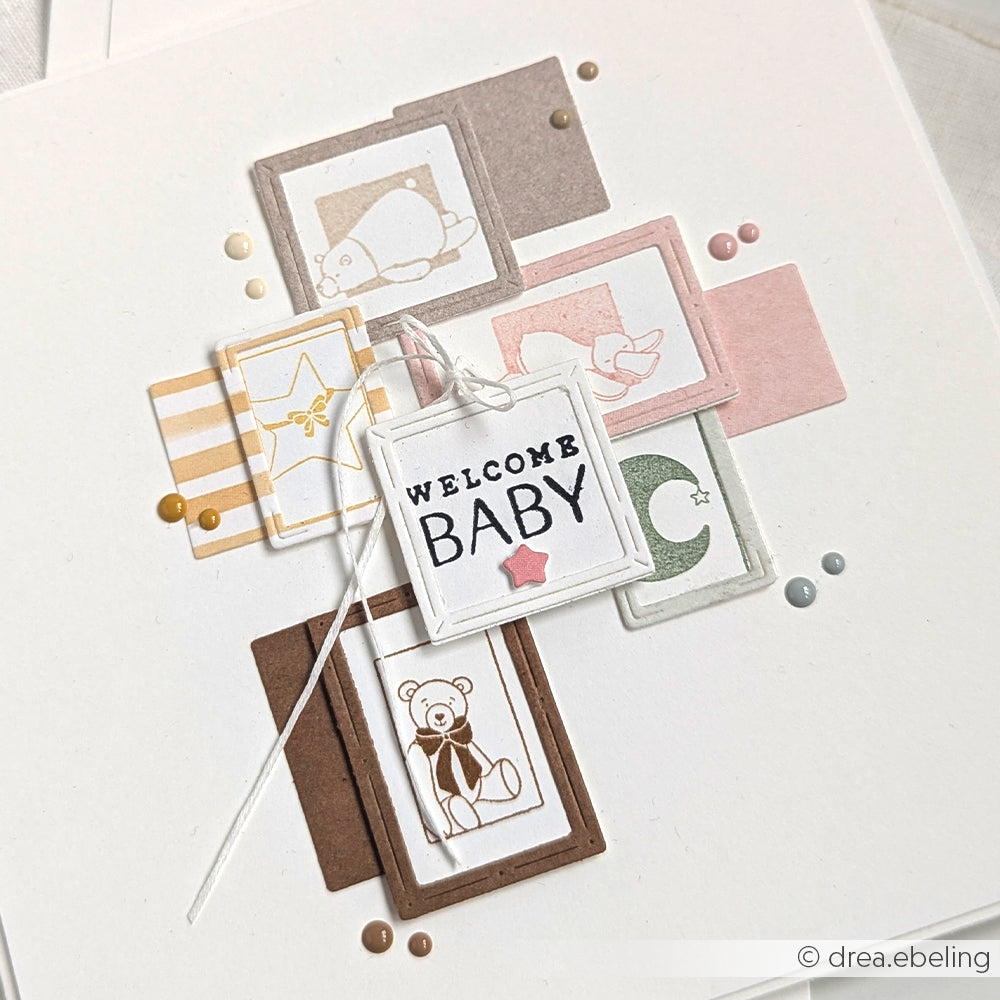 Eine Welcome-Baby-Karte von Alexandra Renke mit pastellfarbenen Tierquadraten, Sternen, einem Teddybär und einer süßen schlafenden Ente auf weißem Untergrund - perfekt zu kombinieren mit Ihren Lieblingsdesigns von Holzstempel oder Stempelgummi.