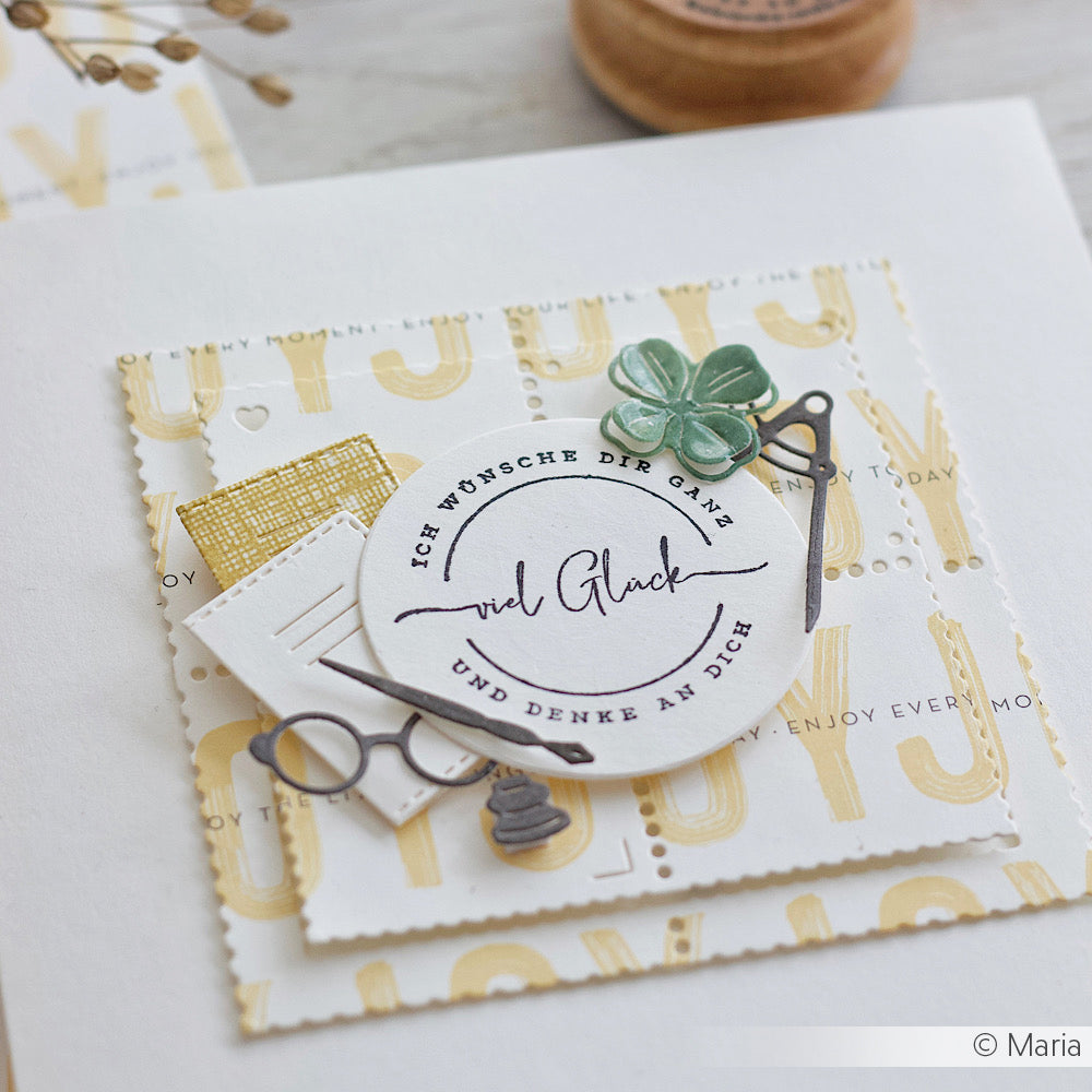 Handgefertigte Karte von Alexandra Renke mit deutschem Text, Scheren-, Klee- und Notenmotiven auf weiß-goldenem Hintergrund - ideal für Stempeln-Anfänger oder alle, die mit einem Viel Glück Stempel eine persönliche Note hinzufügen möchten.