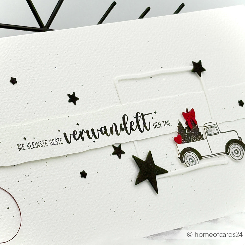 Handgefertigte Karte von Alexandra Renke mit deutschem Text, schwarzen Sternen und einem Lastwagen, der einen Weihnachtsbaum und rote Geschenke transportiert - ideal für Papierprojekte oder in Kombination mit Ihrem Lieblingsholzstempel.