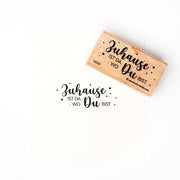 Ein Holzstempel von Alexandra Renke mit dem deutschen Spruch "Zuhause ist da, wo Du bist." - perfekt für kreative Papierprojekte und liebevolle Gestaltungen.