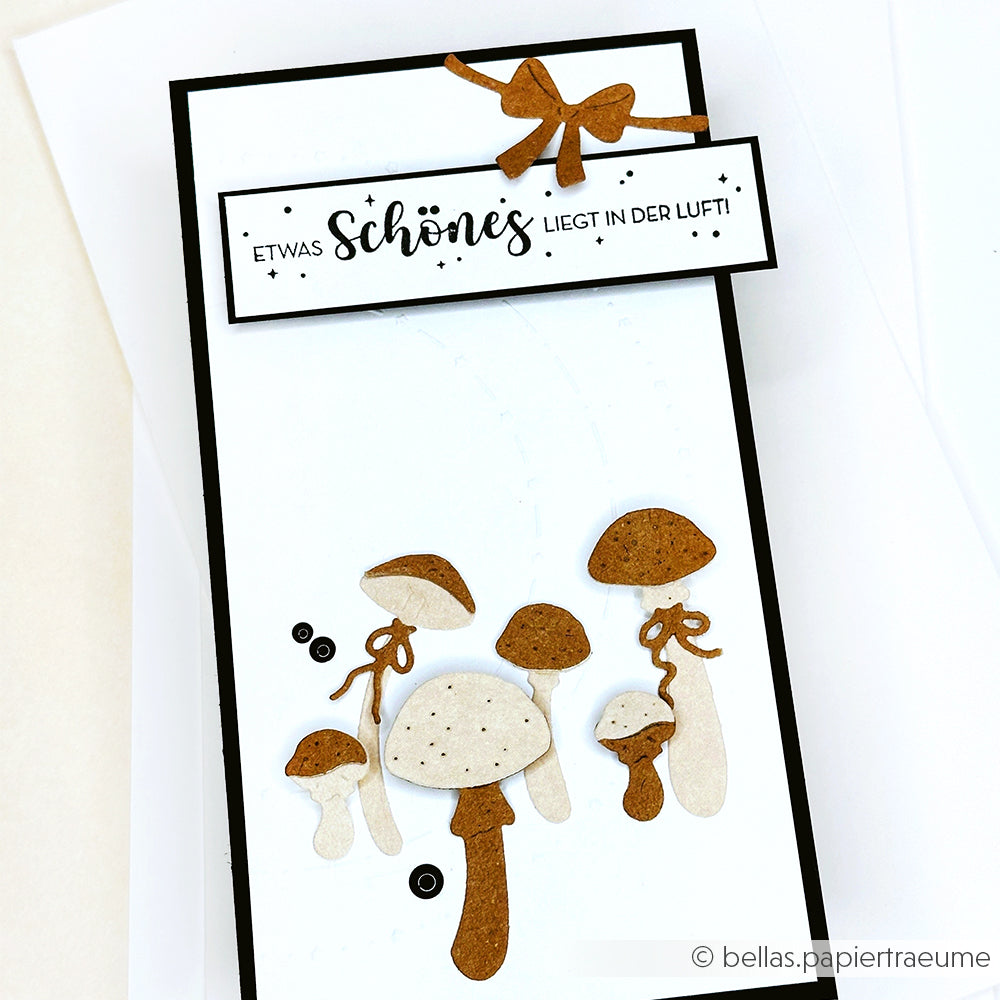 Handgefertigte Karte von Alexandra Renke mit braunen und weißen Pilzen, schwarzen Pailletten und einer deutschen Botschaft auf Weiß - ideal für Papierprojekte oder zum Stempeln mit Ihrem Lieblingsholzstempel.