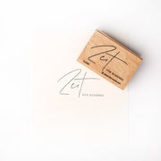 Ein hölzerner Alexandra Renke Holzstempel und Stempelkissen stehen neben gestempeltem Papier mit dem Schriftzug "Zeit FOR SCHÖNES" in eleganter Schrift - ideal für Papierprojekte.