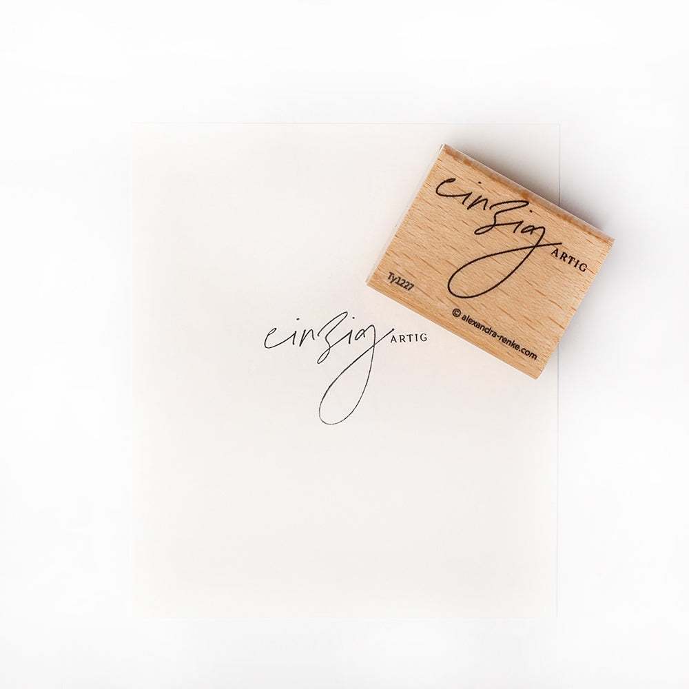 Dieser Holzstempel von Alexandra Renke ist ein Holzquadrat mit schwarzer Schrift, perfekt um Ihren Papierprojekten eine einzigartige Note zu verleihen.