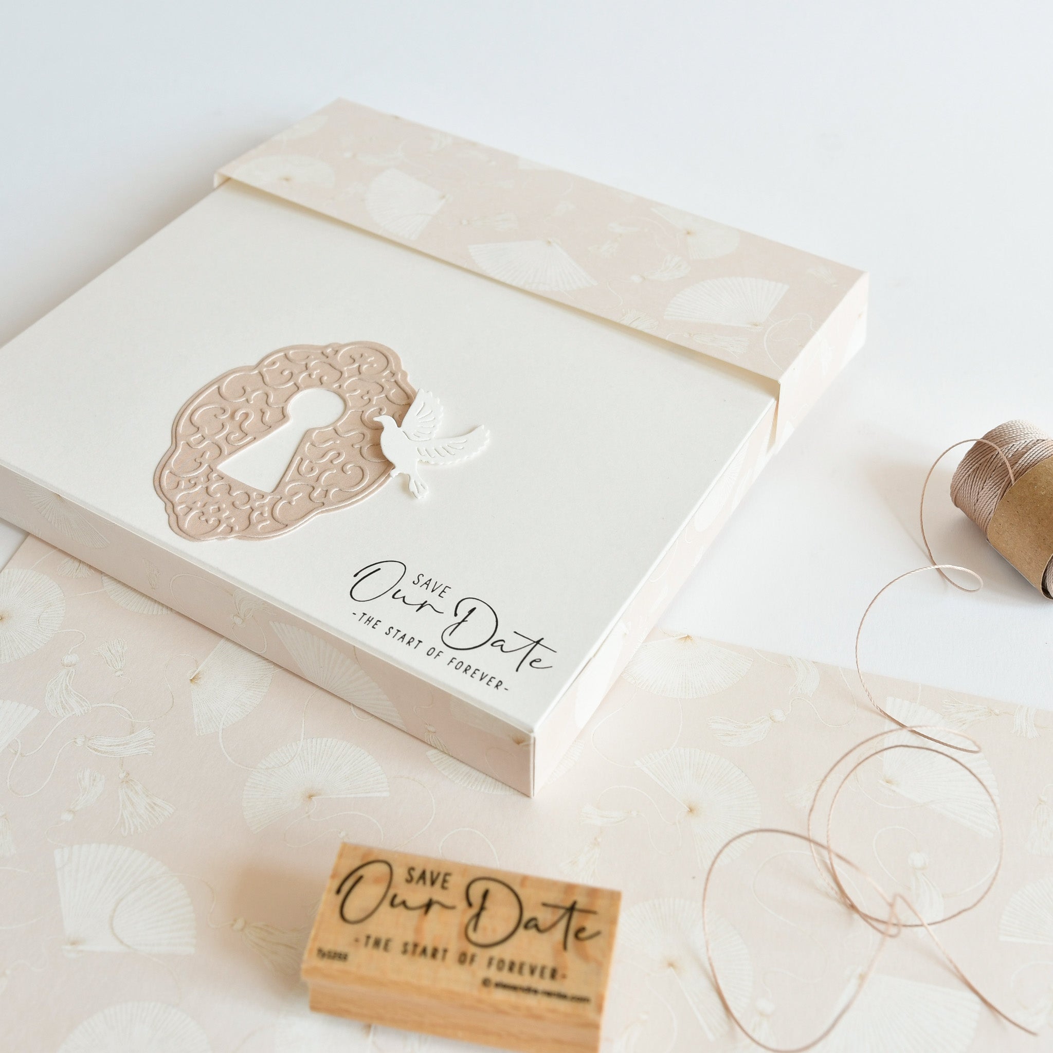 Elegante "Save Our Date"-Hochzeitseinladung mit einem Schlüsselloch- und Vogelmotiv von Alexandra Renke, umgeben von Holzstempeln und Bastelmaterial von Stempel für Papierprojekte.