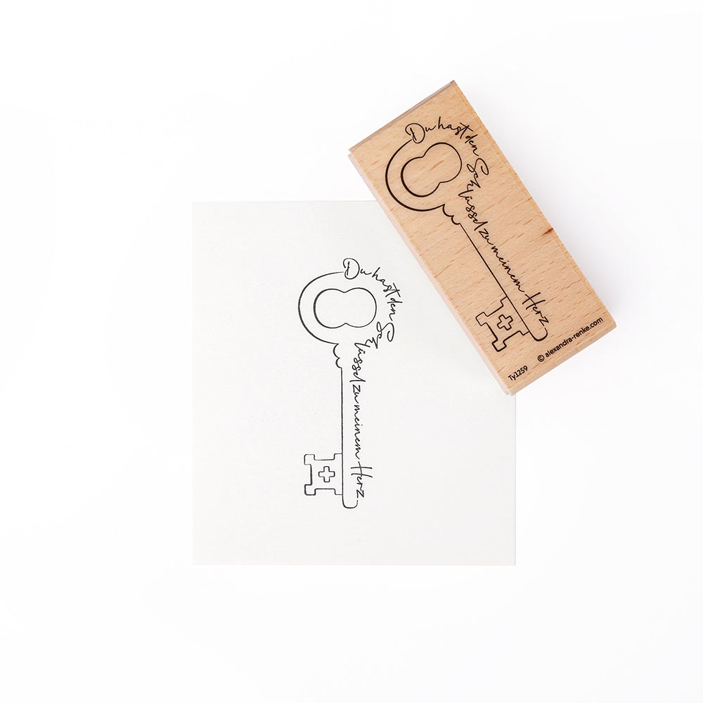 Ein Alexandra Renke Holzstempel mit Vintage-Schlüssel und eleganter Schreibschrift steht auf weißem Hintergrund - ideal für Papierprojekte oder kreative Anwendungen mit Stempelgummi.