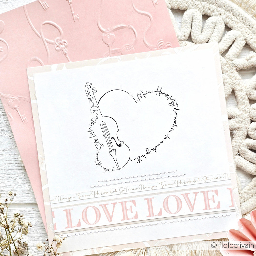 Eine herzförmige Geigenzeichnung mit handgeschriebenem Text auf einer rosafarbenen und weißen Karte zum Thema LIEBE von Alexandra Renke - perfekt für Papierprojekte oder in Kombination mit Ihren Lieblings-Holzstempel-Designs.