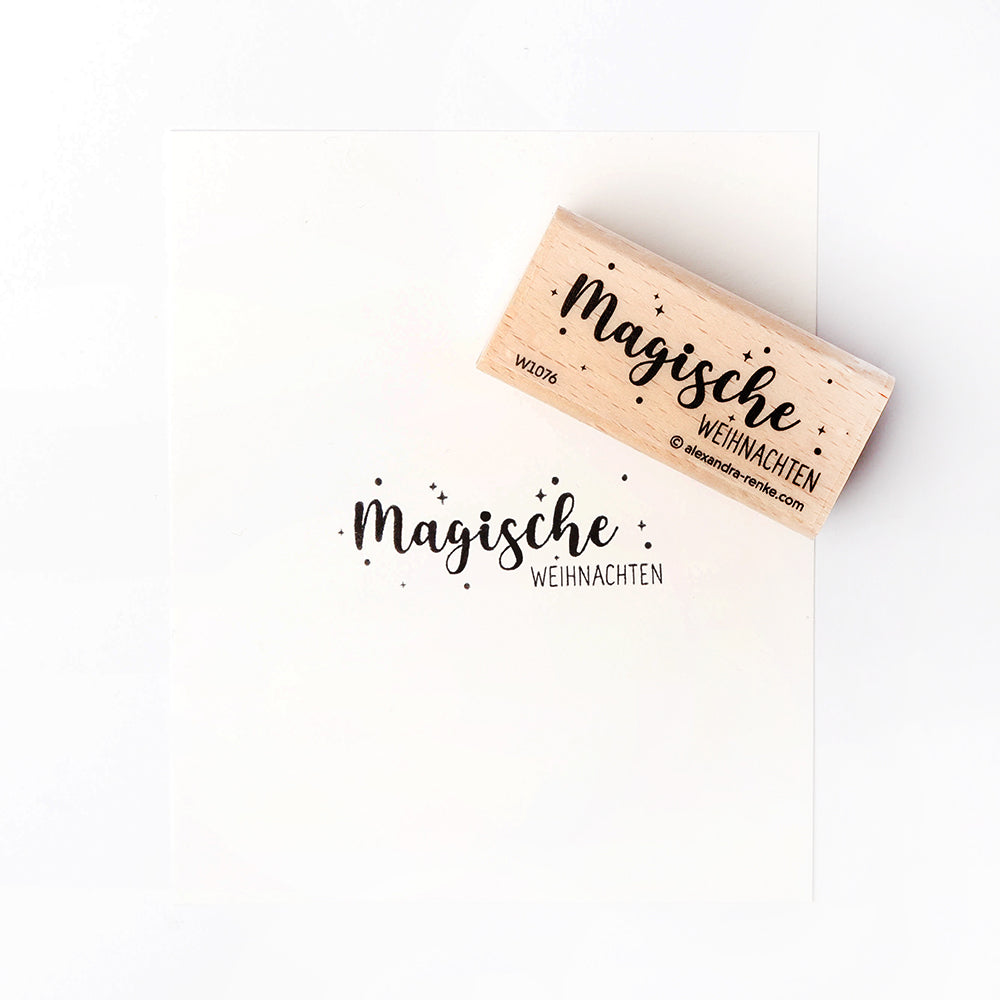 Ein Alexandra Renke Holzstempel druckt "Magische Weihnachten" mit festlichen Stempelmotiven und Sternen auf knackig weißes Papier.
