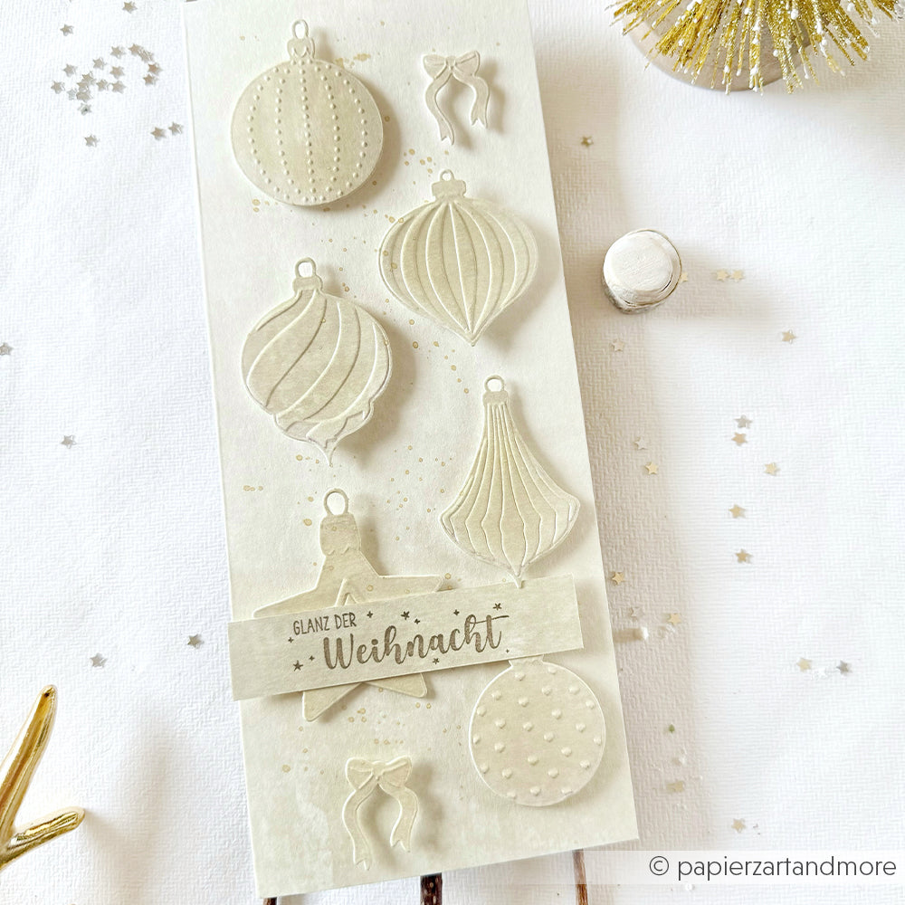 Handgefertigte Weihnachtskarte von Alexandra Renke mit goldenen Ornamenten, Sternen und dem Text "Glanz der Weihnacht" auf hellem Hintergrund - perfekt, um Ihren Lieblingsweihnachtsstempel oder Ihr Bastelzubehör zu verwenden.