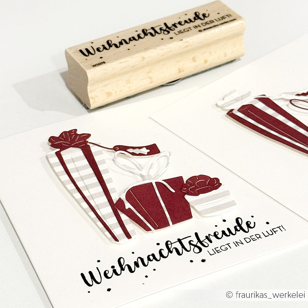 Zwei Weihnachtskarten mit roten Geschenken und deutschem Text sowie ein bezaubernder Holzstempel mit der gleichen festlichen Botschaft von Alexandra Renke - ideal zum Basteln Ihrer eigenen Stempelmotive in dieser Weihnachtszeit.