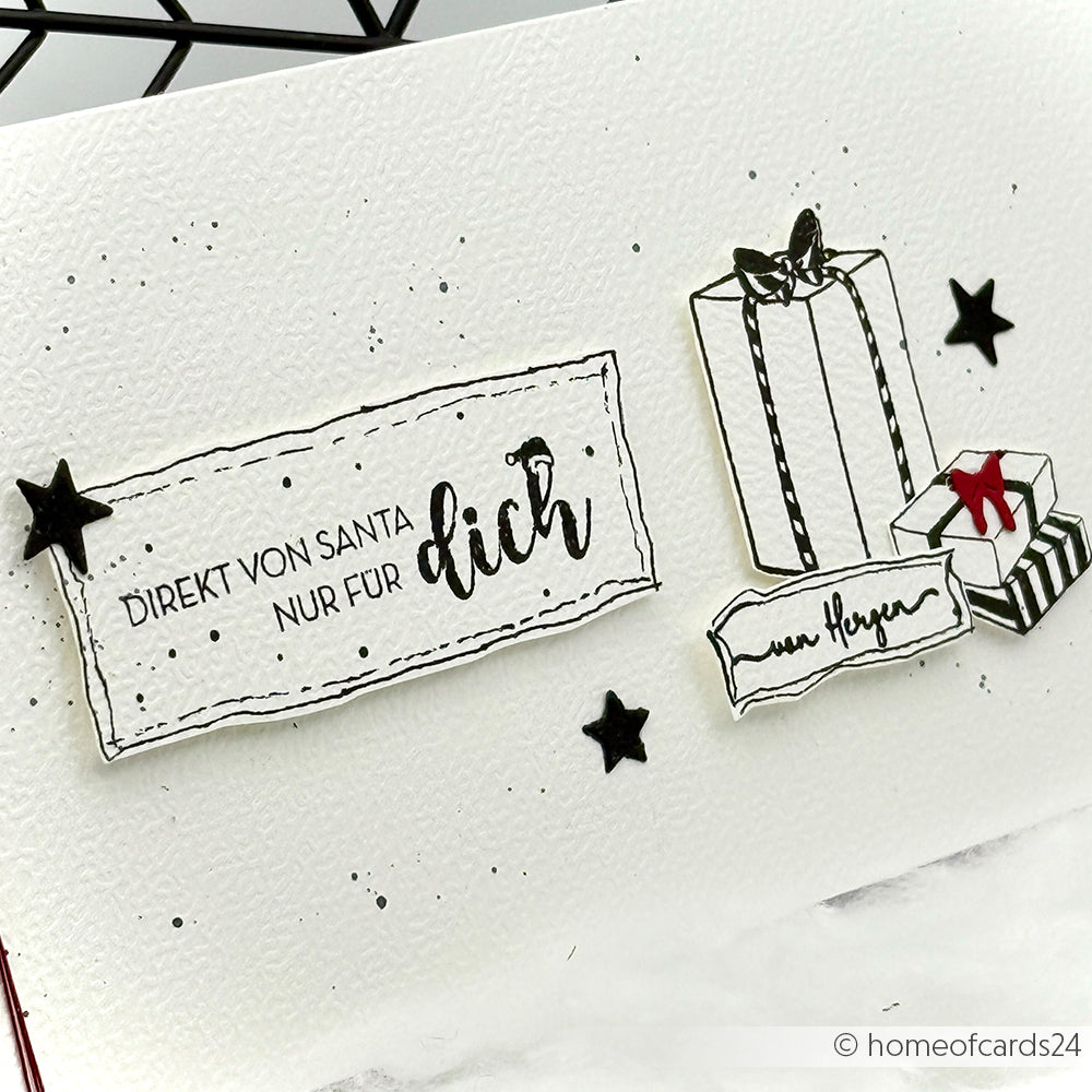 Handgefertigte Karte von Alexandra Renke mit deutschem Text, schwarzen Sternen und drei Abbildungen von Geschenkboxen (eine davon mit roter Schleife). Mit charmanten gestempelten Details mit Stempelkissen und Holzstempel.