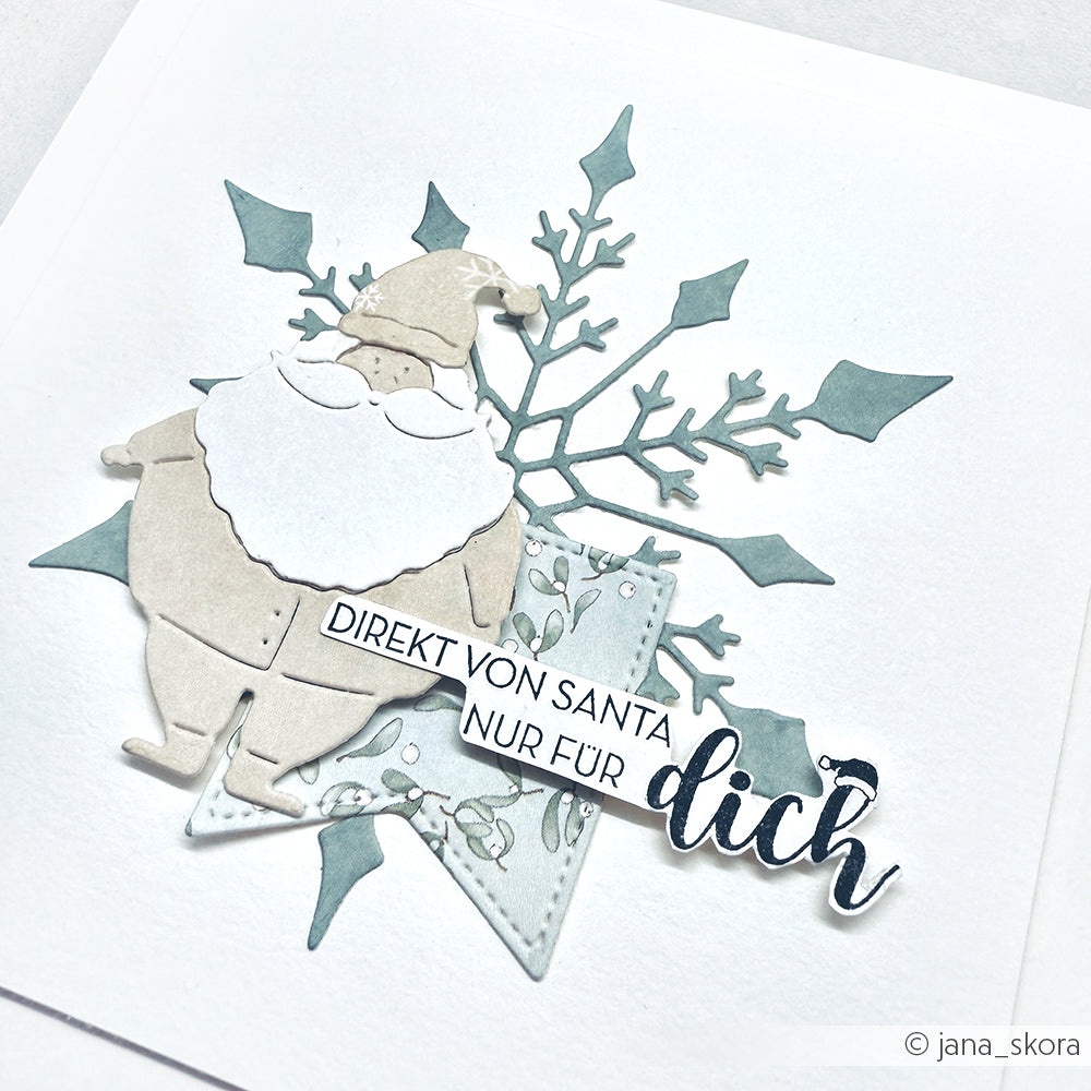 Ein Papier-Weihnachtsmann und eine Schneeflocke mit "Direkt von Santa nur für dich" auf weißem Hintergrund von Alexandra Renke, ideal zum Kombinieren mit Ihren Lieblings-Holzstempeln oder Stempelkissen für festliche Bastelarbeiten.