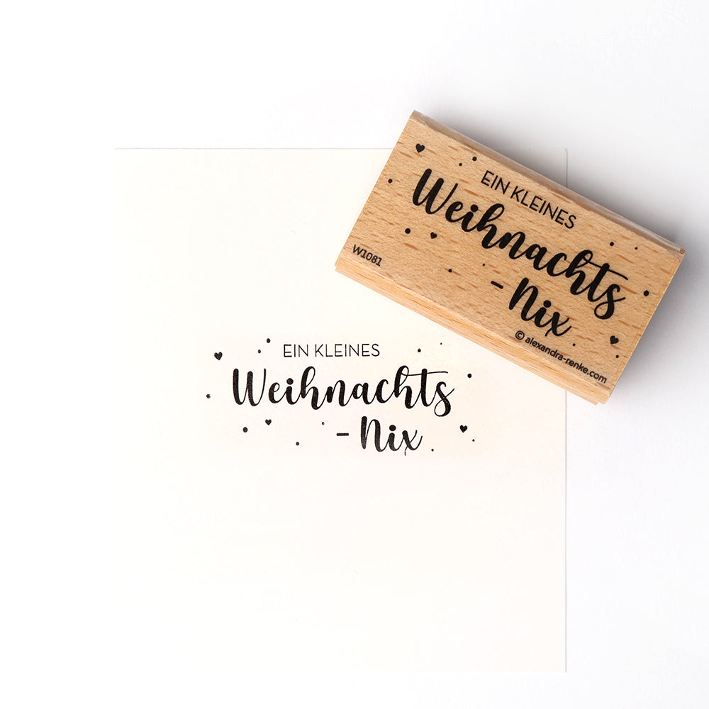 Ein Alexandra Renke Holzstempel stempelt EIN KLEINES Weihnachts-nix auf weißes Papier - ideal, um mit dem Lieblings-Weihnachtsstempel einen festlichen Akzent zu setzen.