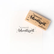 Ein Holzstempel von Alexandra Renke mit dem deutschen Text "BESINNLICHE Adventszeit" und Sternen - perfekt für Papierprojekte und kreative Bastelarbeiten.