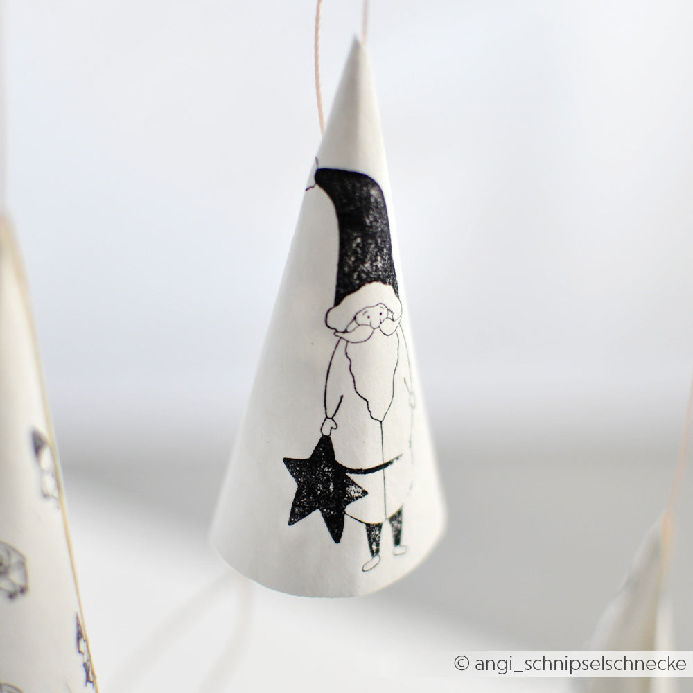 Das Ornament aus Papierkegeln von Alexandra Renke zeigt einen handgezeichneten Weihnachtsmann, der einen Stern hält und an einer Schnur aufgehängt ist - perfekt, um eine einzigartige Weihnachtsdekoration zu basteln.