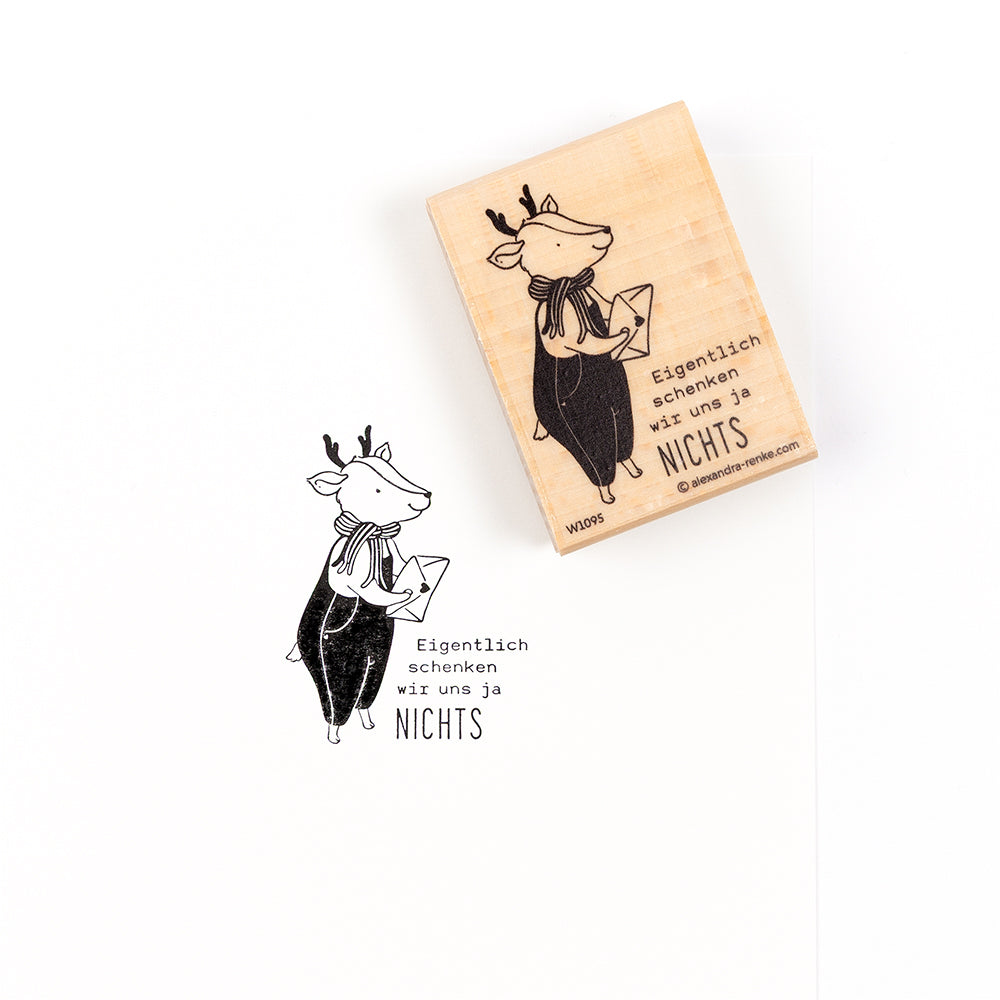 Ein Holzstempel mit der Abbildung eines Rentiers, das einen Umschlag mit dem deutschen Text „Eigentlich schenken wir uns ja NICHTS..“ hält, geeignet für verschiedene Papierprojekte.