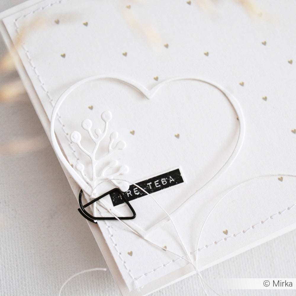 Weiße Karte von Alexandra Renke aus Designpapier mit einer Herzrahmenstanze, kleinen goldenen Herzen und einem schwarzen Etikett mit PRE Teba in weißer Schrift.