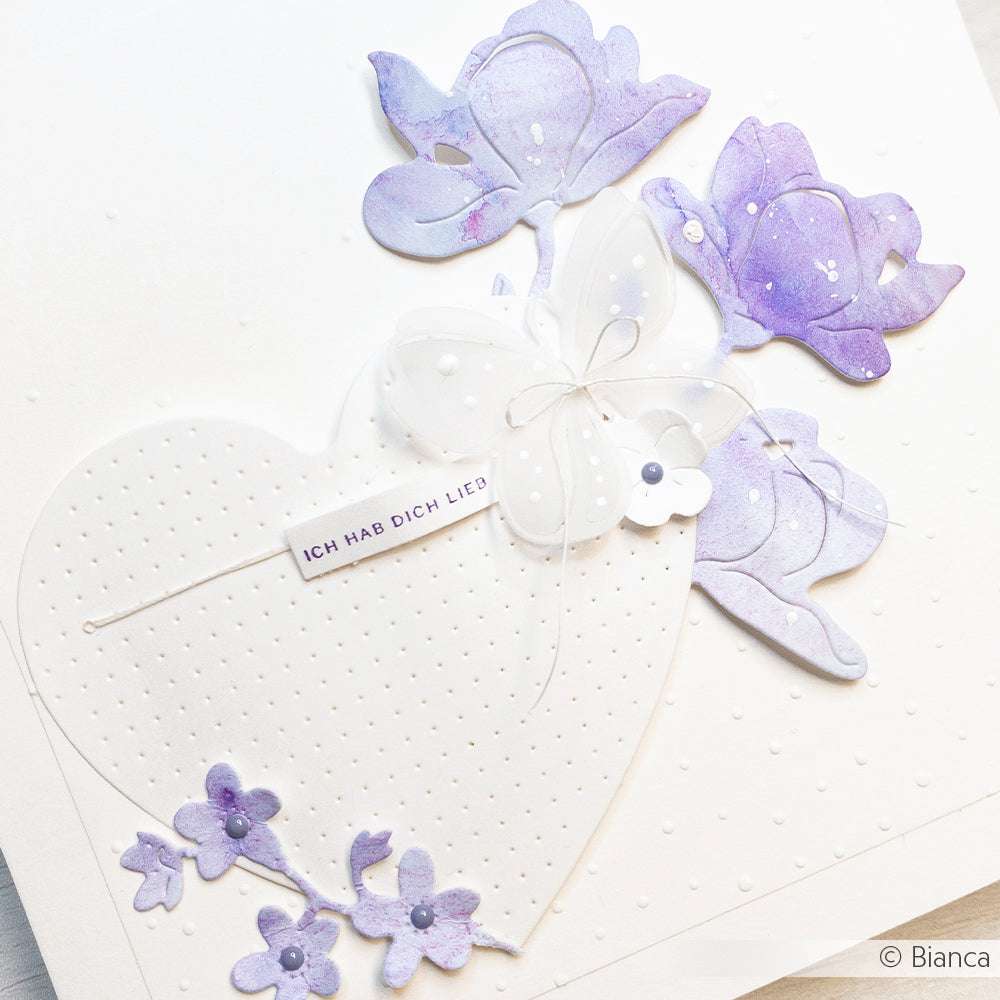Handgemachte Alexandra Renke Karte mit weißem Herz (Motivstanze Herzen), lila Blumen und einem Schmetterling. Text: ICH HAB DICH LIEB.