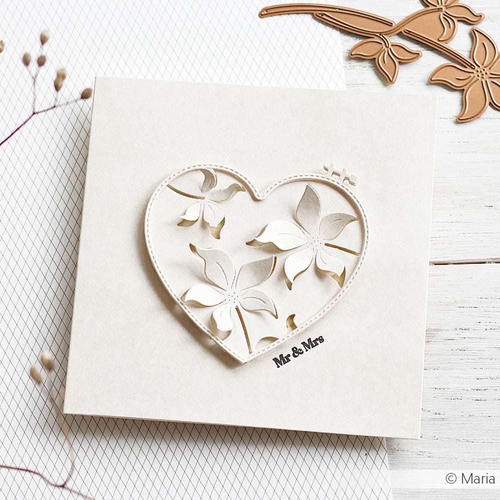 Quadratische cremefarbene Karte mit herzförmigem Blumenausschnitt, hergestellt mit Alexandra Renke Stanzformen, mit dem Text "Mr & Mrs" auf einer weißen Holzoberfläche.