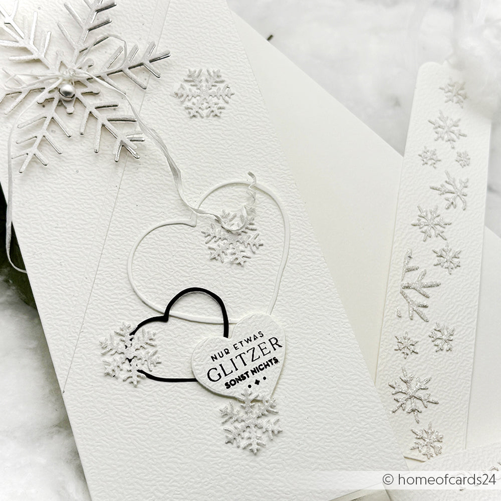 Weiße, strukturierte Grußkarte von Alexandra Renke mit geprägten Schneeflocken, einem Schneeflocken-Ornament und Herzen, die mit den Motivstanze Herzen Dies hergestellt wurden - perfekt für festliche Kreationen.