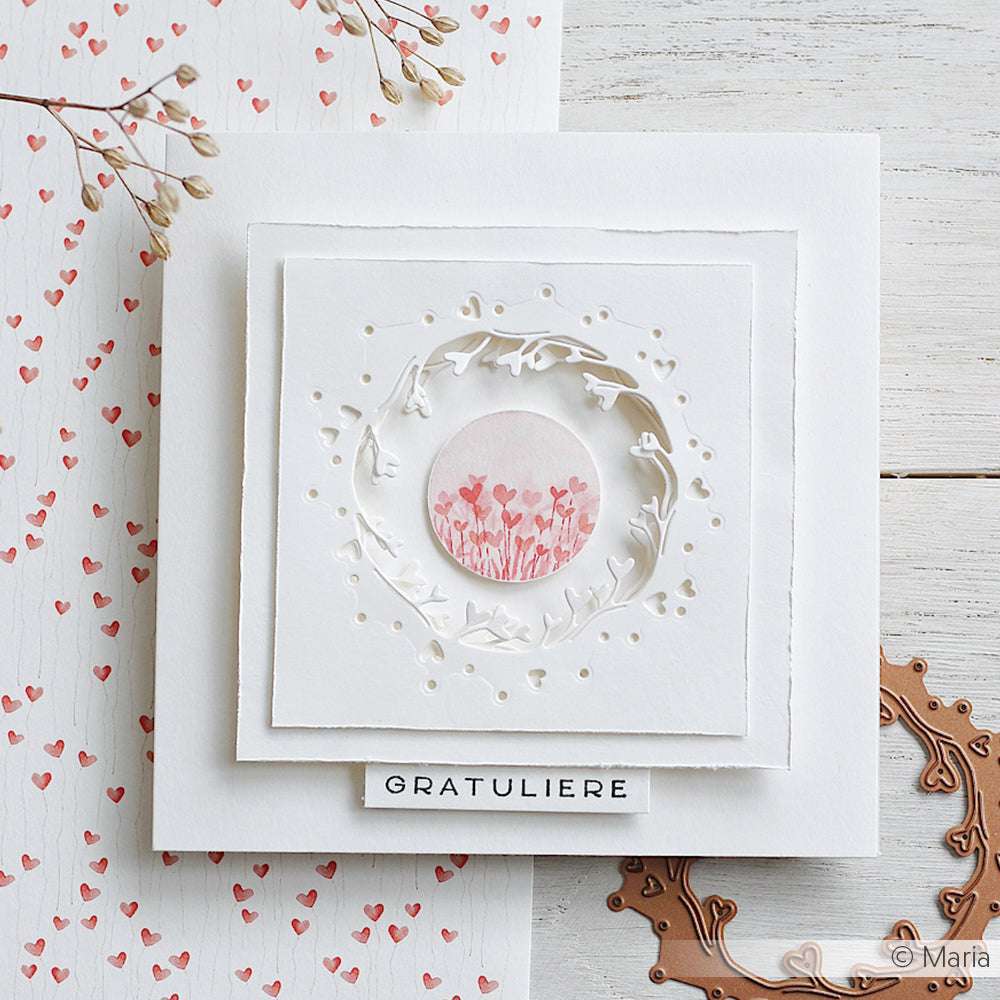 Handgefertigte weiße Karte von Alexandra Renke mit zartem Blumenkranz und rosa Herzen aus Motivstanze Negativ-Kranz, unten mit "GRATULIERE" beschriftet, auf stabilen 200g Designpapieren für einen edlen Look.