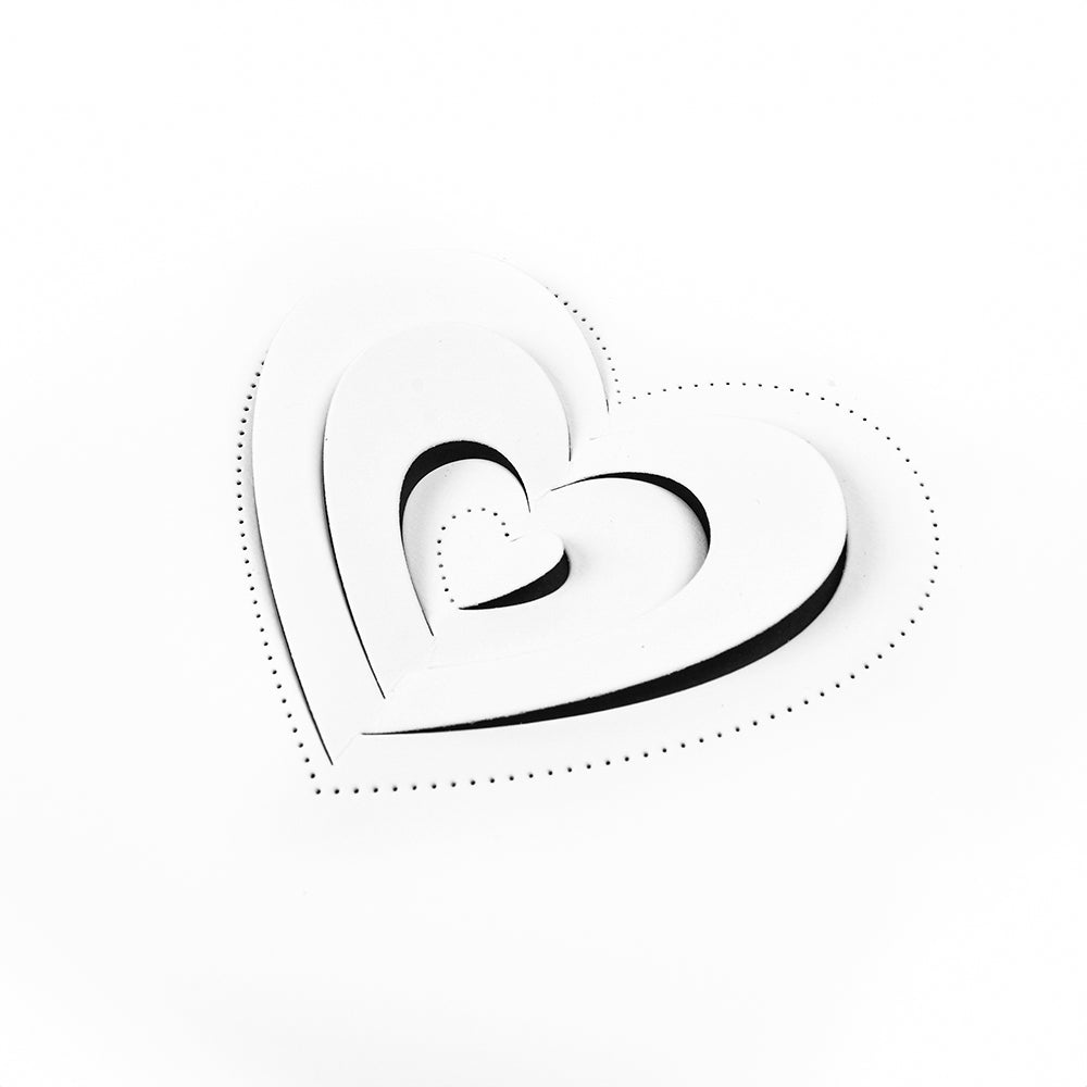 Drei übereinander liegende weiße Papierherzen mit gepunkteten Umrissen, hergestellt mit Alexandra Renke Designpapieren und einer Motivstanze Pop-Up Herz, auf einem schlichten weißen Hintergrund.