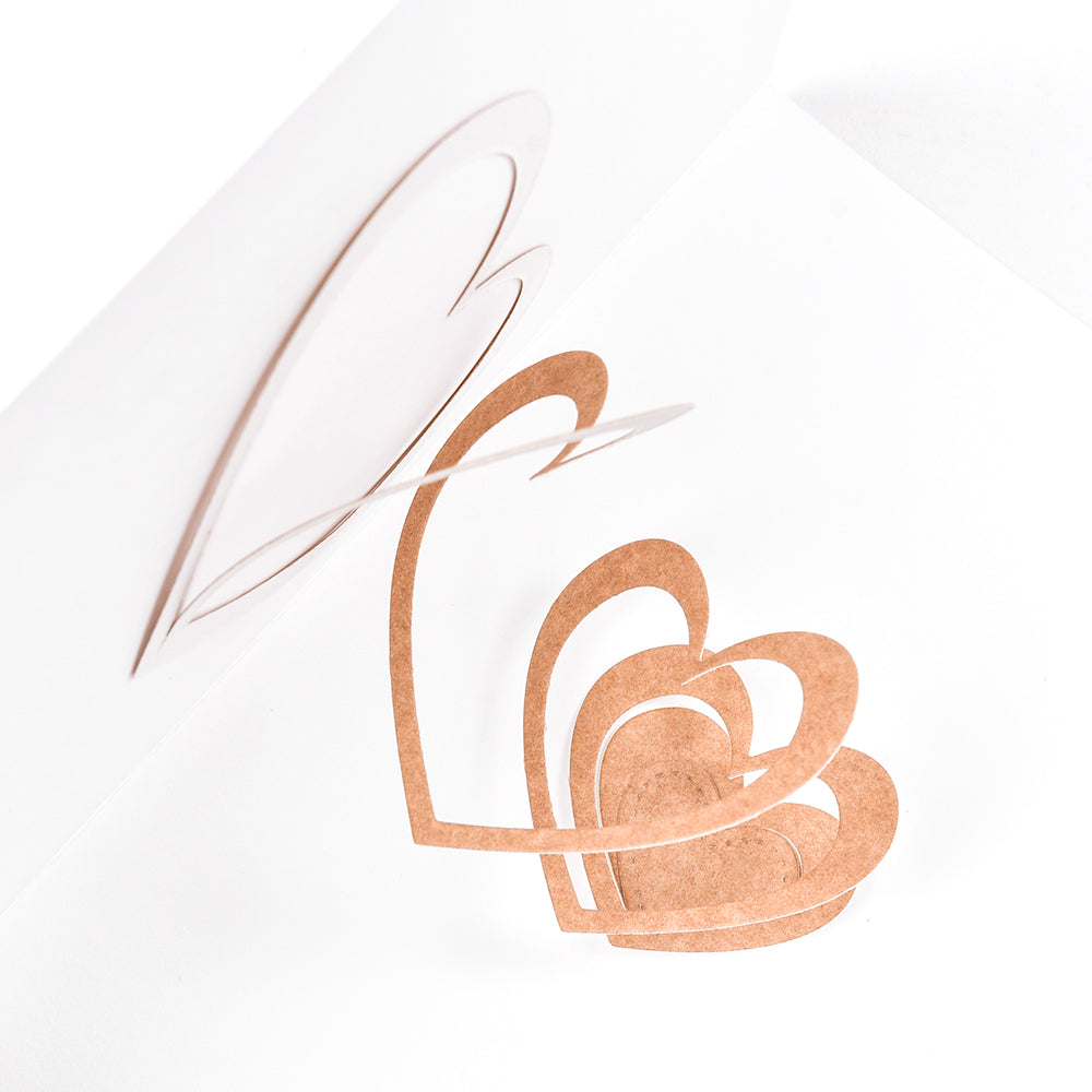 Pop-up-Karte mit geschichteten Herzformen, hergestellt mit der Alexandra Renke Herzspirale Stanze, steht innen vor einem schlichten weißen Hintergrund.