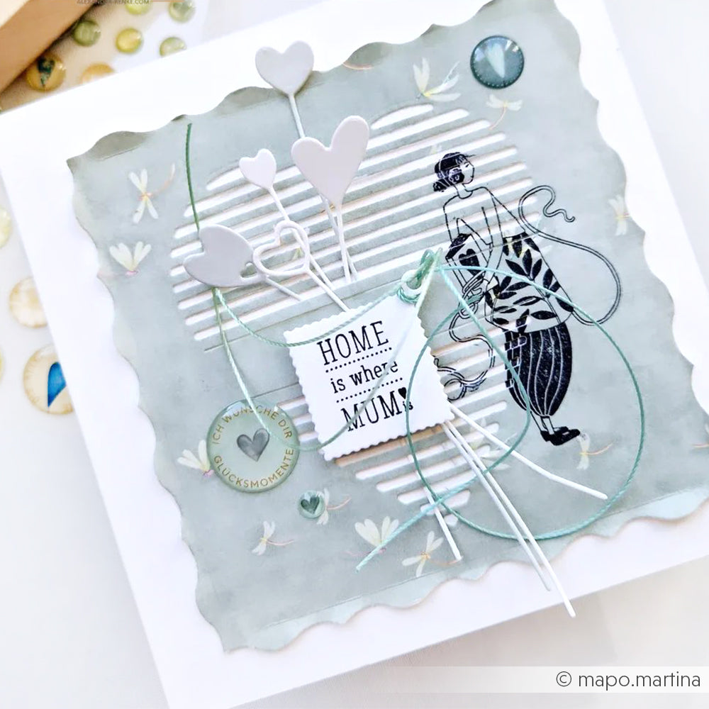 Handgefertigte Karte mit Herzen aus der Motivstanze Herzchen am Stiel von Alexandra Renke, einer Frauenillustration und einer Notiz "HOME is where MUM is" auf weichem grauen Designpapier.