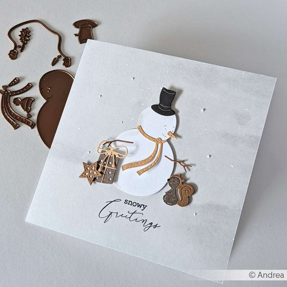 Handgemachte Karte von Alexandra Renke mit einem Schneemann, Geschenken, einem Eichhörnchen und "verschneiten Grüßen" auf hellem Hintergrund, hergestellt mit Motivstanze für präzise Details.