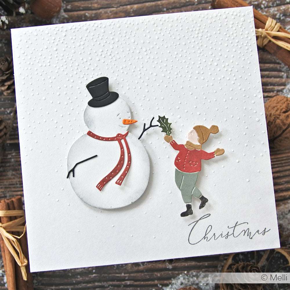 Eine Weihnachtskarte von Alexandra Renke mit einem Schneemann und einem Kind mit Stechpalme, "Weihnachten" in Schreibschrift und aus hochwertigen Designpapieren für einen festlichen Touch.