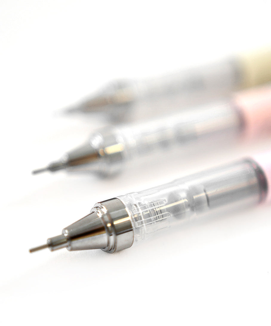 Drei Druckbleistifte mit klarem Schaft und silberner Spitze, diagonal angeordnet auf weißem Hintergrund.