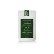 Ein Beutel Zimt-Apfel-Tee mit einem deutschen Text über Geschenke und Zeit mit der Familie.