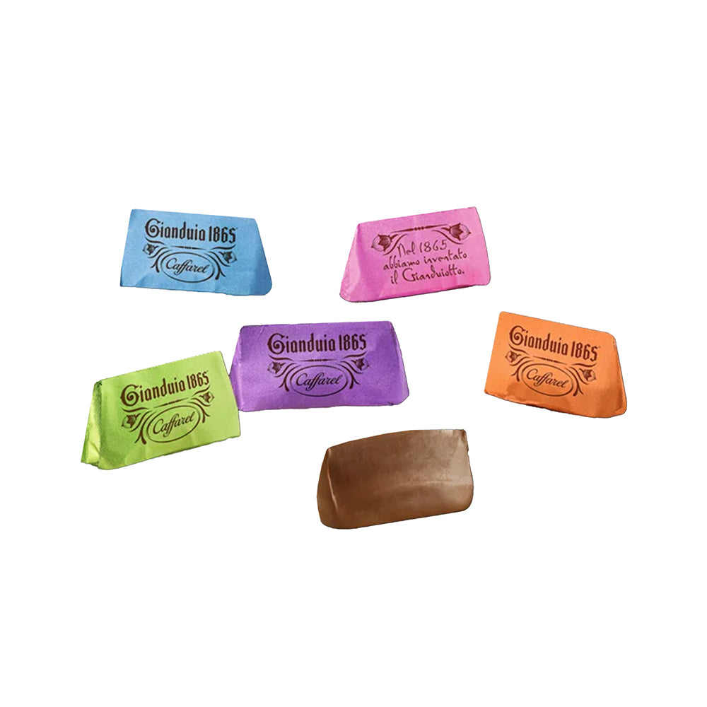 Fünf bunt verpackte Gianduiotto-Pralinen und ein unverpacktes Stück.