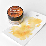 Ein kleiner Krug Lindy's Stamp Gang Bayou Boogie Gold, ein hochpigmentiertes Pulver, steht neben einem Tag, der mit der einzigartigen Farbgebung des schimmernden Gold-Aquarells bemalt ist.